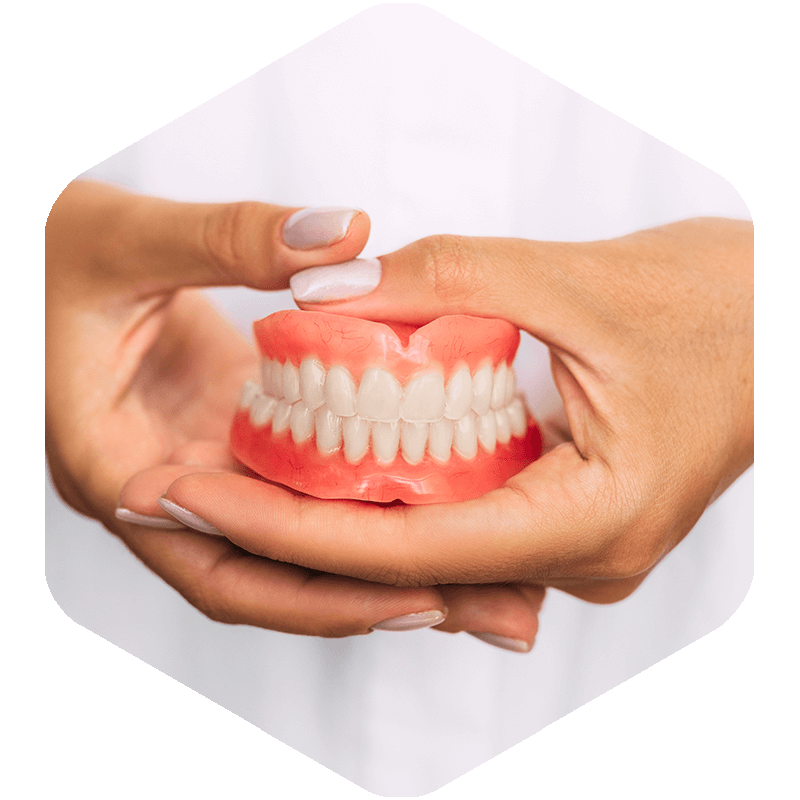 Hands holding a set of dentures.