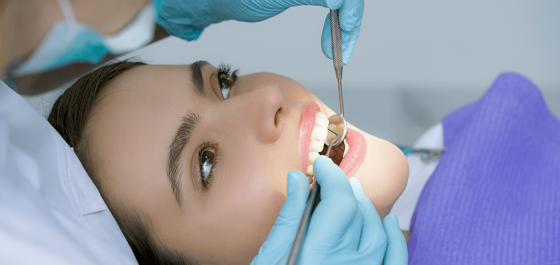 Dentist cleaning patient's teeth.