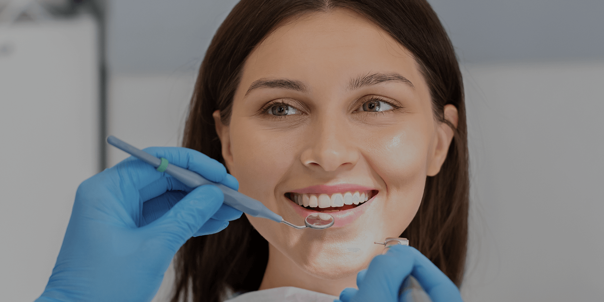 Woman smiling at dentist with dental tools around her.
